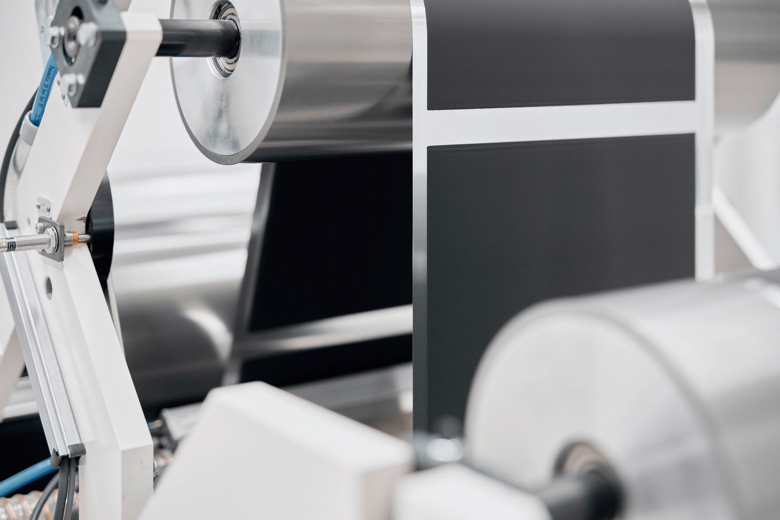 An industrial machine processes thin electrode foils for battery cells.