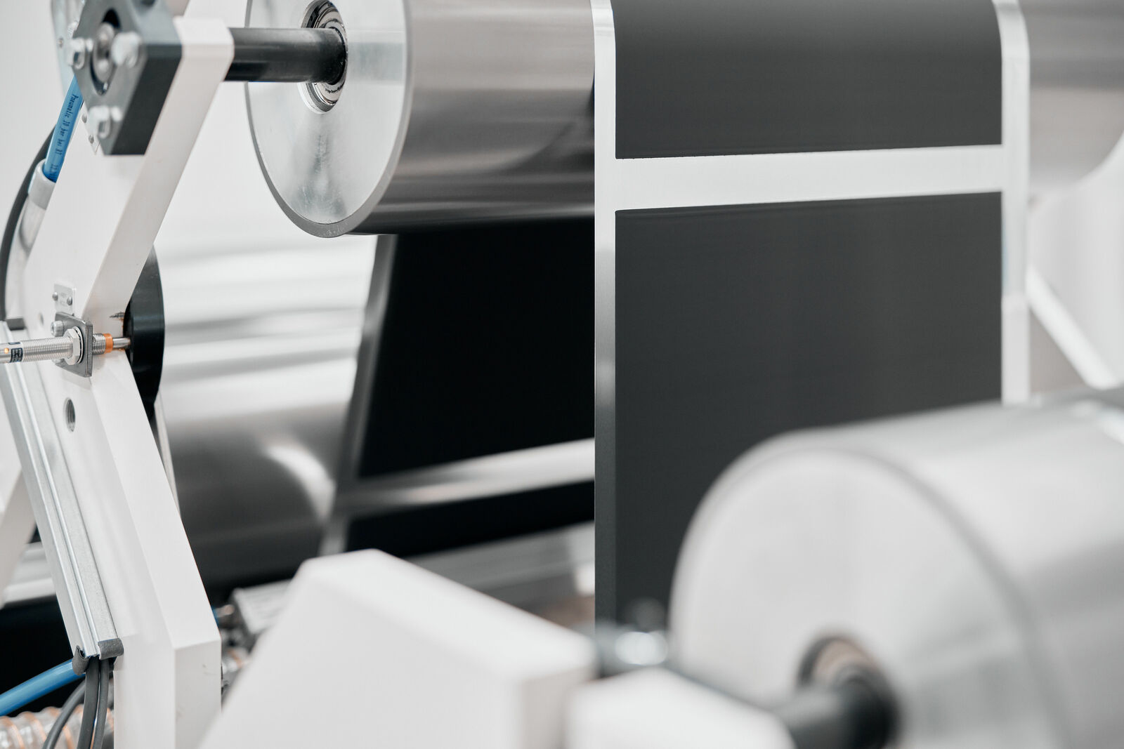 Eine Maschine verarbeitet dünne Folienrollen für die Batterieproduktion.