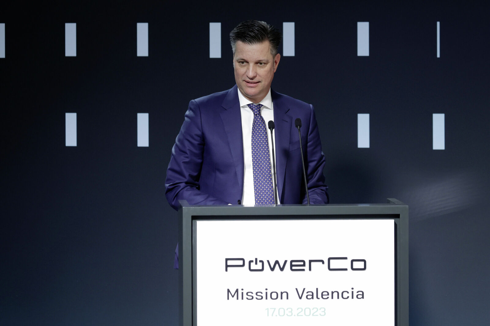 A man in a suit speaks at the PowerCo event “Mission Valencia” on 17.03.2023 at a podium.