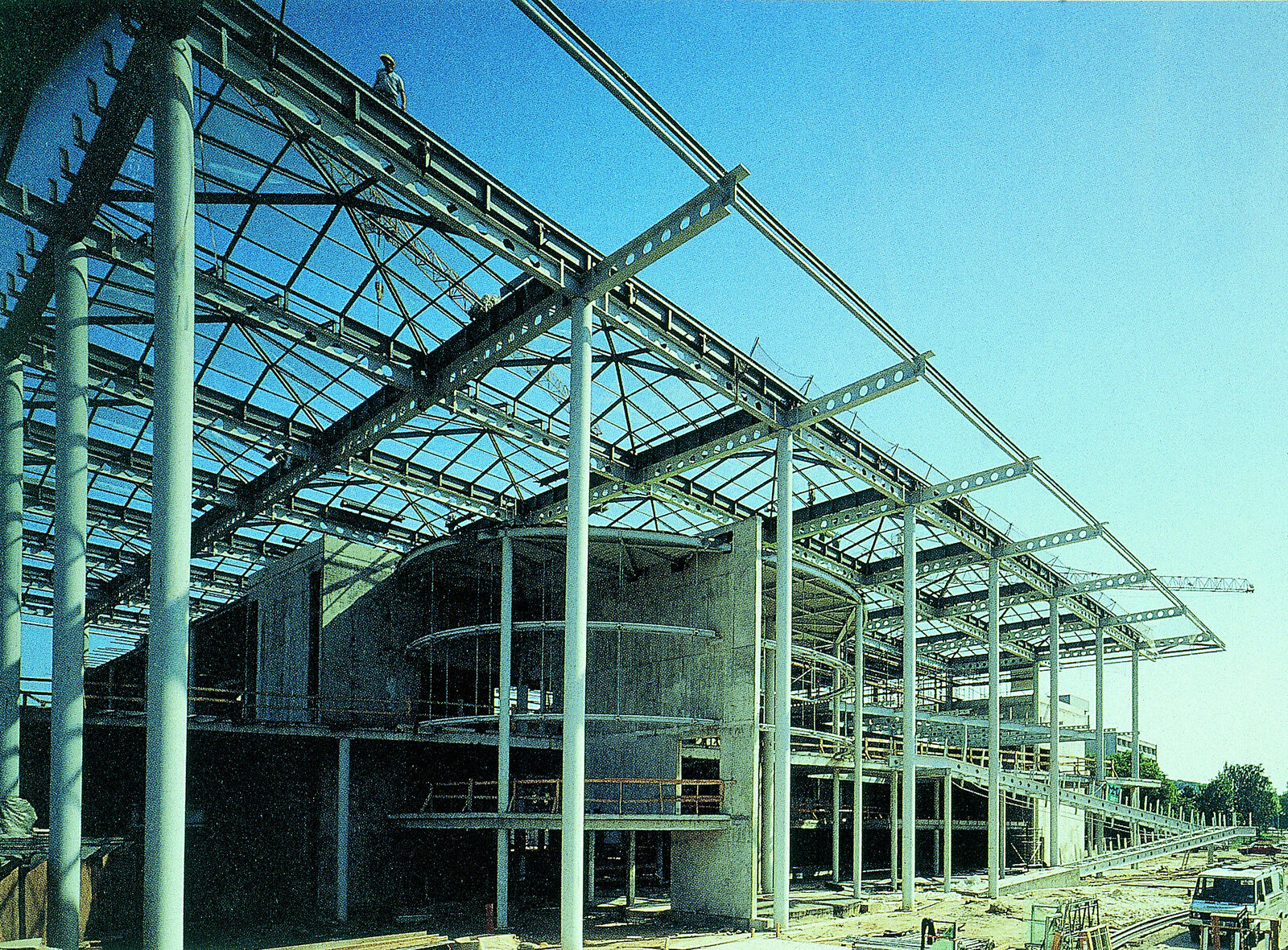 Eine Baustelle mit einem großen Stahlgerüst, das den Aufbau eines modernen Gebäudes zeigt.