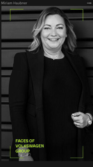 Portrait of Miriam Haubner smiling, in a black and white photo, dressed in a dress and a blazer, titled 'Faces of Volkswagen Group'.