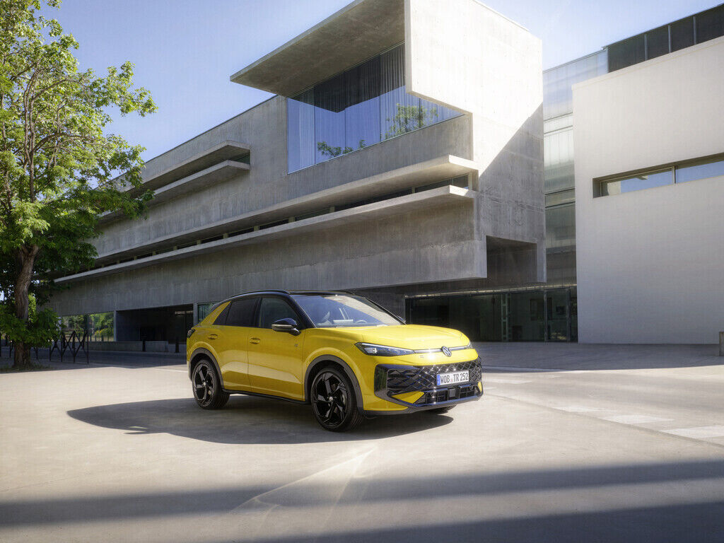 Gelber Volkswagen SUV vor modernem Gebäude.
