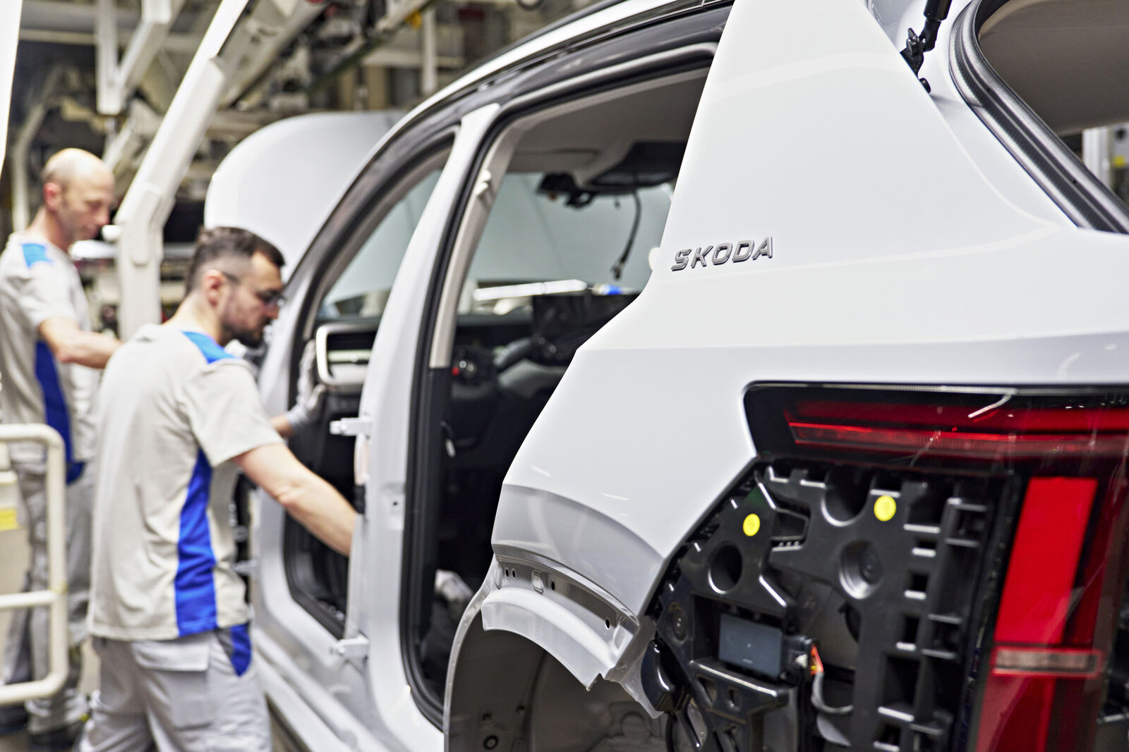 Worker inspecting car taillight on assembly line