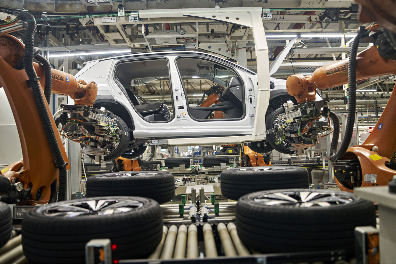 Car body in automated production line with robotic arms