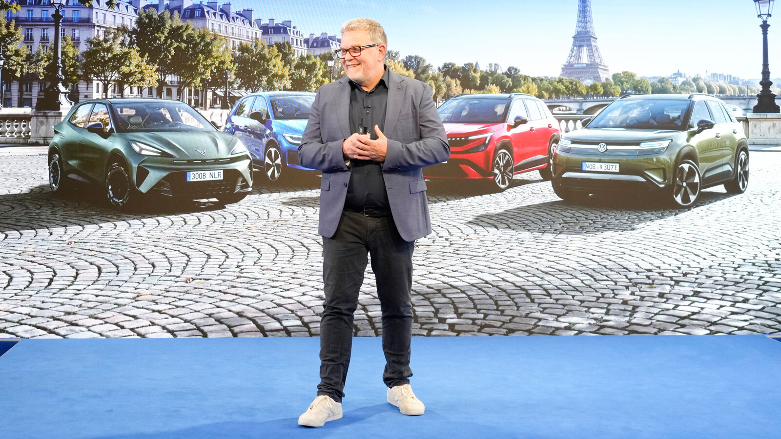 Andreas Mindt (Leiter Volkswagen Group Design) mit der Electric Urban Car Family im Hintergrund.