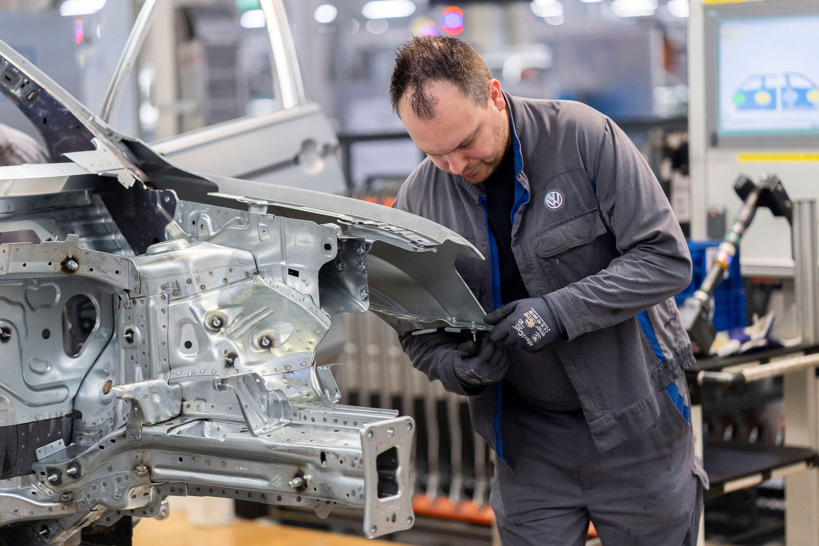 Body-shop Wolfsburg plant: An employee assembles a wing to a body