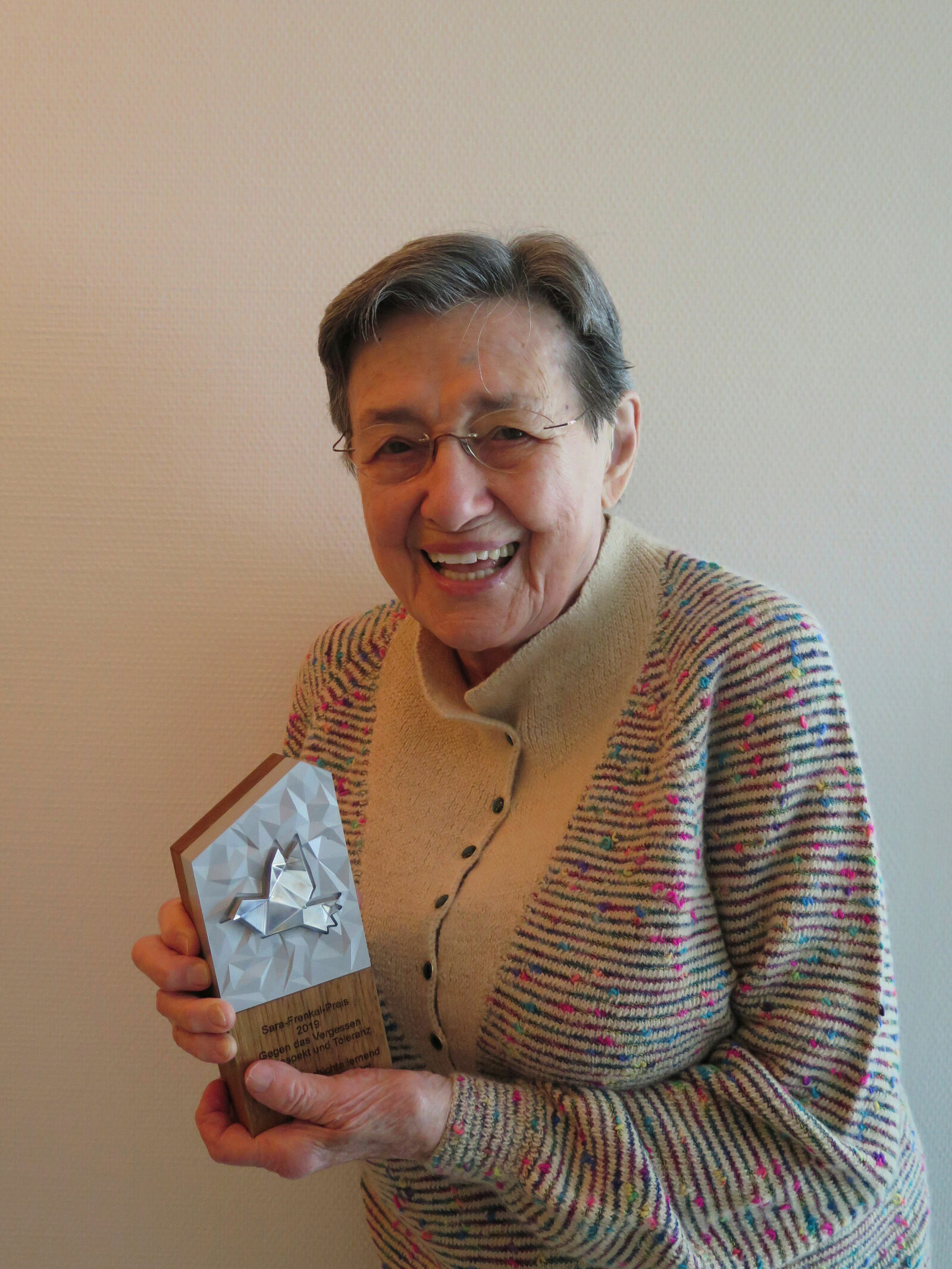 Sara-Frenkel-Preis: Namenspatronin Sara Frenkel-Bass (97) hält die schwere Skulptur aus Holz und Metall fest in ihren Händen. Die Ehrenauszeichnung der Jury ist das „Urmeter“ des Sara-Frenkel-Preises für Respekt, Toleranz und Zivilcourage, der dieses Jahr erstmals vergeben wurde.